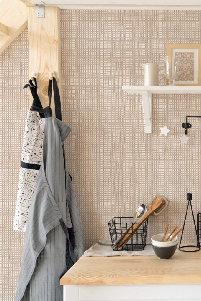Aprons and utensils hanging against French Bakery Subtle Lines wallpaper in a minimalist kitchen setting. The soft, textured pattern creates a warm and inviting backdrop, ideal for rustic décor or creative cooking spaces.