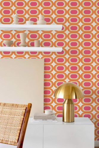 Retro peel and stick wallpaper with bold pink, orange, and yellow oval pattern styled in a modern room with brass lamp and shelf decor.