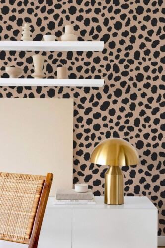Aesthetic Cheetah Print Wallpaper in beige and black, featuring a bold animal print pattern styled in a modern space with a white console, brass dome lamp, floating shelves with sculptural ceramics, and a woven wood chair. The abstract cheetah spots create a striking, textured backdrop that adds energy and style to contemporary interiors.