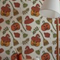 Aesthetic Halloween peel and stick wallpaper with pumpkins, witch hats, brooms, and leaves in cozy autumn-themed entryway