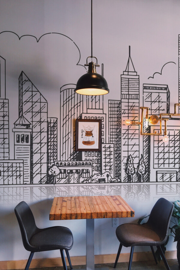 Peel and stick wall murals featuring hand-drawn city buildings in linear style with reflective skyline effect in black and white. The Fancy Walls peel and stick or non-pasted wallpaper.