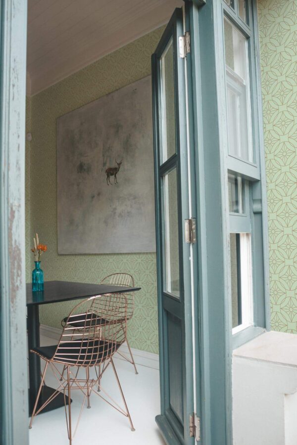 Minimal coastal style cafe decorated with Art deco green peel and stick wallpaper