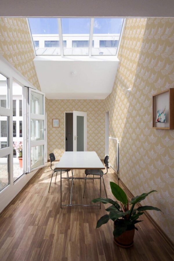 Minimal style dining room next to a balcony decorated with Art deco wings peel and stick wallpaper