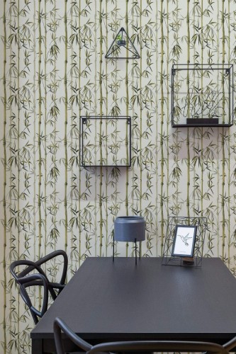 Bamboo wallpaper with vertical green stalks on a neutral background, displayed in a modern dining space featuring a black table, matching chairs, and geometric metal shelves.