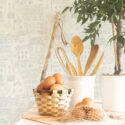 Kitchen counter scene with eggs, utensils, and natural textures placed in front of the beige city wallpaper design. The wallpaper’s calm, illustrated townscape creates a cozy and nostalgic setting perfect for cafés, cottage-style kitchens, or bakery-inspired interiors. Fancy Walls’ soft neutral pattern brings understated charm to walls while maintaining a fresh, airy look.