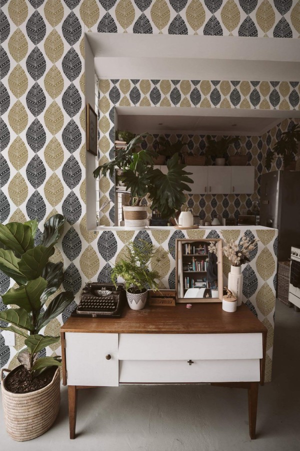 Boho style living room and kitchen decorated with Black and beige leaf peel and stick wallpaper and green plants