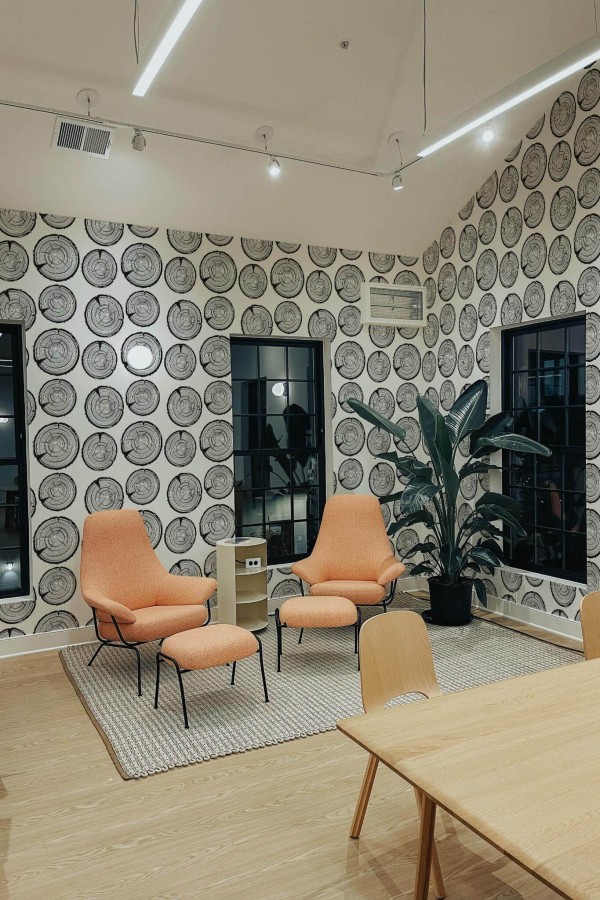 Minimal style living room decorated with Black and white tree trunk peel and stick wallpaper and mid-century style chairs