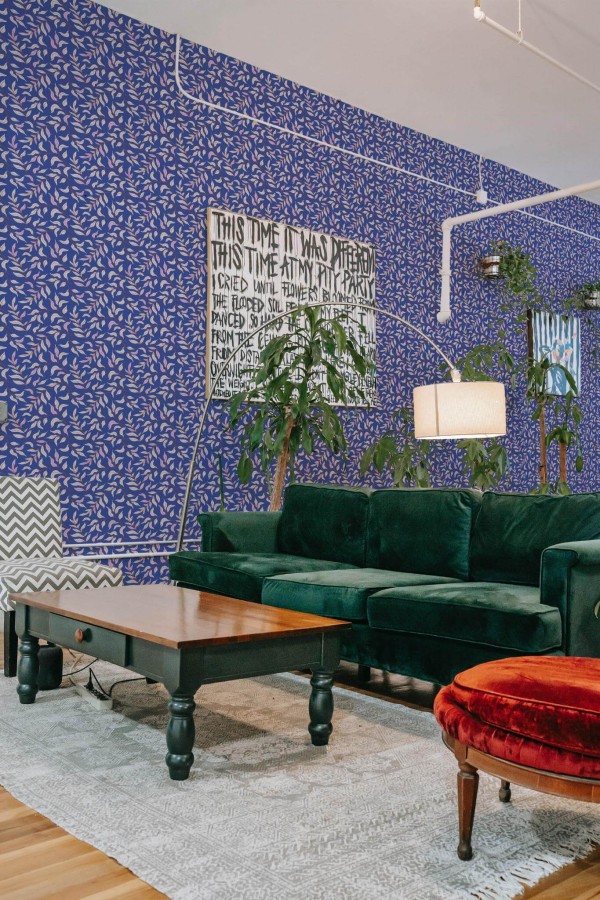 Bold eclectic style living room decorated with Blue leaf peel and stick wallpaper and emerald green sofa
