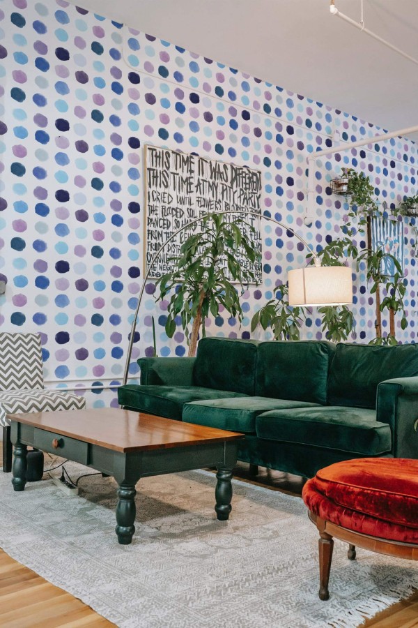 Bold eclectic style living room decorated with Blue watercolor dotted peel and stick wallpaper and emerald green sofa