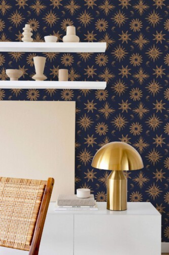 Celestial wallpaper featuring gold sun and moon motifs arranged in a symmetrical pattern across a deep navy background, styled in a modern room with minimalist décor. The Fancy Walls peel and stick or non-pasted wallpaper brings a bold, cosmic flair to a contemporary interior, complementing neutral ceramics, natural textures, and metallic accents. Ideal for accent walls in bedrooms, home offices, or creative studios.