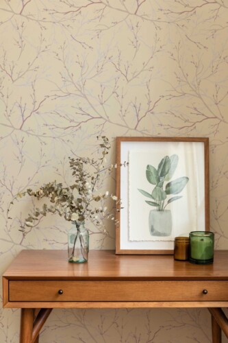 Wooden console table with framed botanical art and vases in front of soft brown plant and tree wallpaper. The wallpaper’s neutral background and earthy branch illustrations add a calming, organic touch, ideal for home spas, entryways, or wellness studios with a modern natural aesthetic.