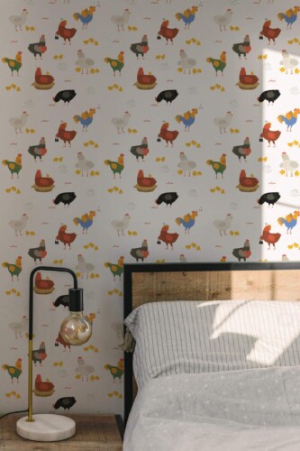 Cute Chicken Wallpaper featuring playful cartoon-style chickens, roosters, hens, and chicks in red, gray, yellow, green, and blue tones on a soft white background. The farmhouse-inspired bird pattern creates a whimsical and cheerful backdrop, styled in a cozy bedroom with a wood headboard, striped bedding, and modern bedside lamp for a warm, rustic look.