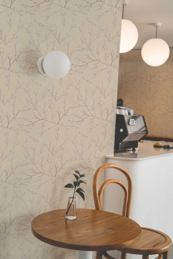 Cozy corner with neutral brown branch-pattern wallpaper, featuring delicate tree silhouettes in soft hues against a light beige background. Styled with wooden furniture and soft lighting, this interior is perfect for cafés, spas, or minimalist living spaces. The design complements Scandinavian and nature-inspired décor themes.