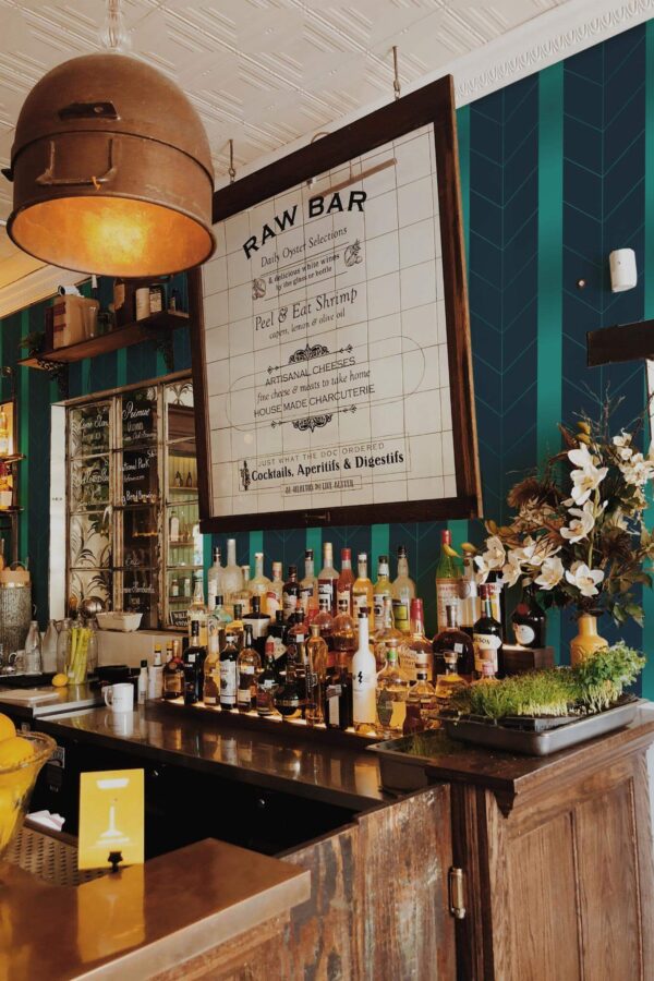 Rustic farmhouse style bar decorated with Elegant teal herringbone peel and stick wallpaper
