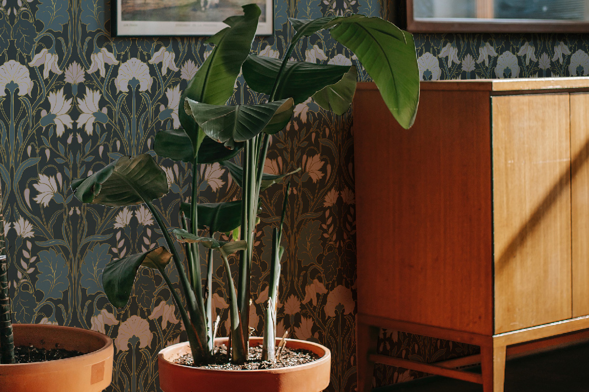 Large tropical plant in terracotta pot against dark green Art Nouveau floral wallpaper – peel and stick, self-adhesive or non-woven design.