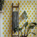 Funky duck peel and stick wallpaper in eclectic room with yellow rubber ducks, wooden ladder, and tropical potted plant