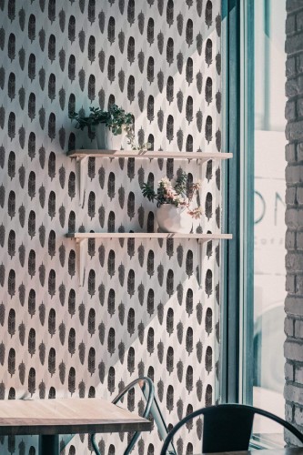 Industrial style cafe decorated with Gray watercolor feather peel and stick wallpaper
