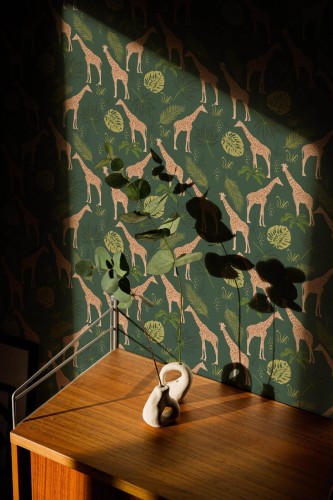 This green wallpaper features playful giraffes amidst tropical foliage, creating a jungle-inspired design that brings nature into your space. The repeating pattern of giraffes with spotted coats and lush plants in shades of green and mustard yellow adds a touch of whimsy and elegance to any room. Ideal for living rooms, nurseries, or kids’ rooms, this design creates a soothing yet exciting atmosphere. The Fancy Walls peel and stick or non-pasted wallpaper is made from eco-friendly, PVC-free materials, printed with GreenGuard Gold certified inks for vibrant, long-lasting color and indoor air quality.