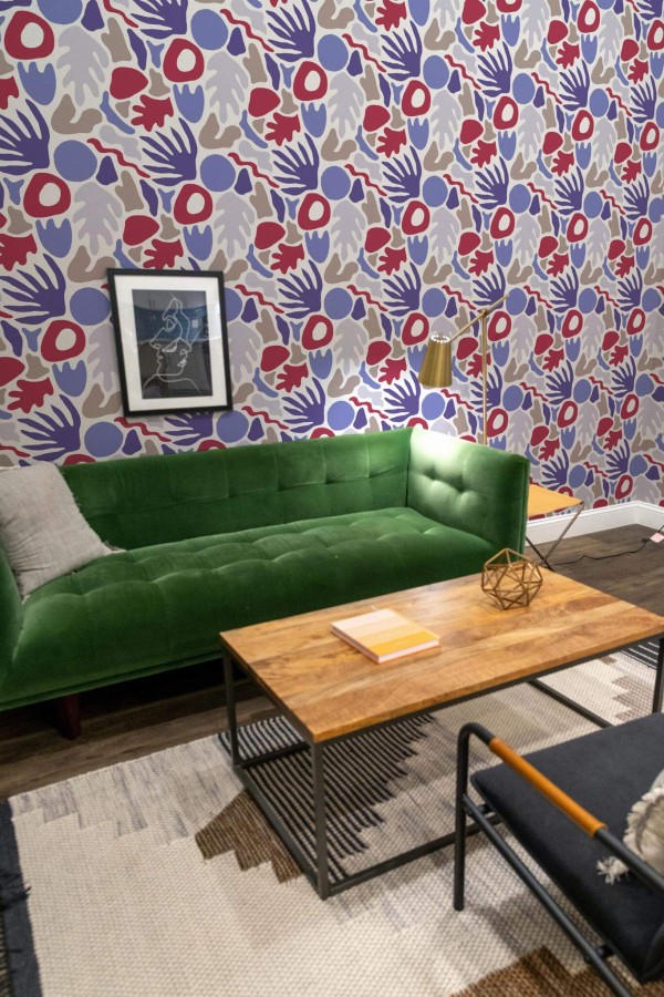 Mid-century modern living room decorated with Multicolor abstract coral peel and stick wallpaper and forest green sofa