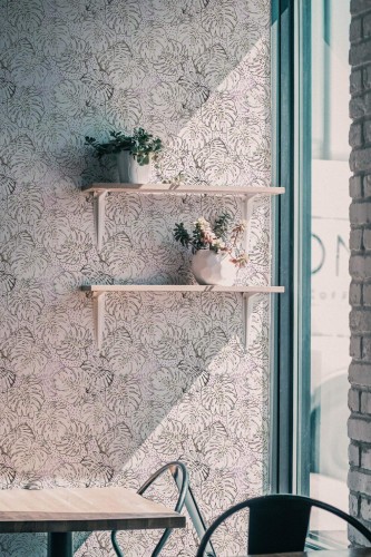 Industrial style cafe decorated with Multicolored monstera leaf peel and stick wallpaper