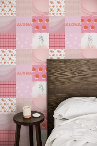 Bedroom featuring a whimsical pink collage wallpaper composed of square tiles with varied patterns, including hearts, fruits, “Aloha” text, and minimalist line-drawn figures. The patchwork design layers soft pastel hues, geometric shapes, and playful prints to create a vibrant accent wall. A dark wooden headboard anchors the right side, complemented by crisp white bedding. A small round wooden nightstand with a simple white candle stands nearby, adding a cozy, modern contrast.