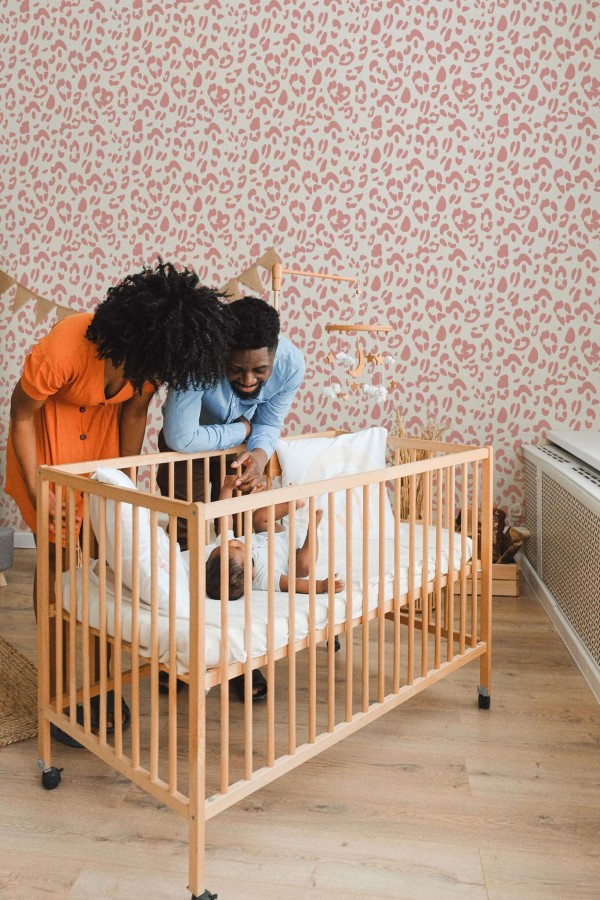 Boho style nursery decorated with Pink leopard print peel and stick wallpaper