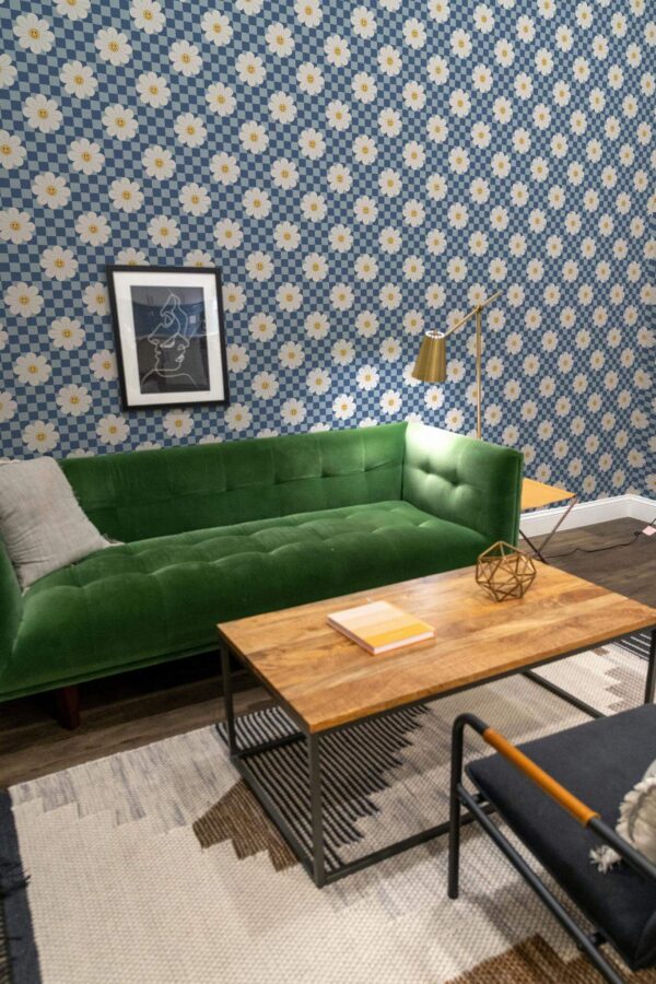Mid-century modern living room decorated with Psychedelic floral peel and stick wallpaper and forest green sofa