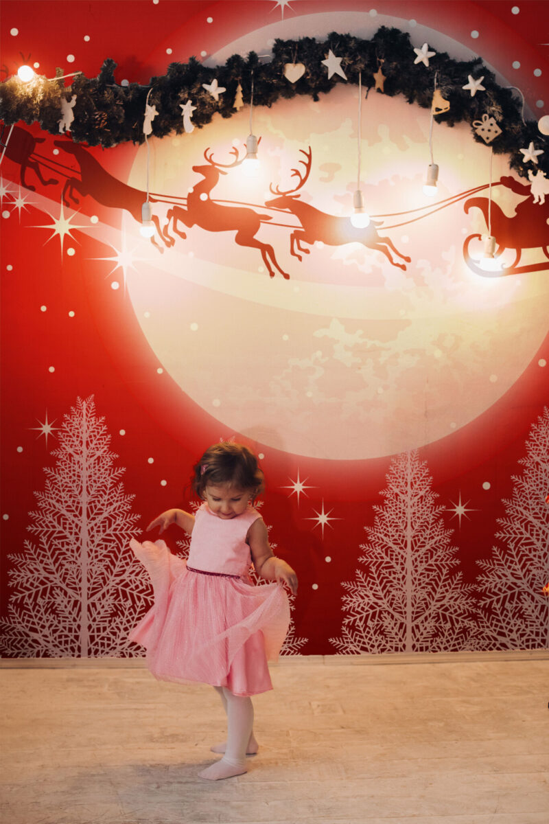 White Forest with Santa Wall Mural featuring a snowy white forest, Santa’s sleigh, and a glowing moon on a bold red background, ideal for living rooms or cozy holiday accent walls.