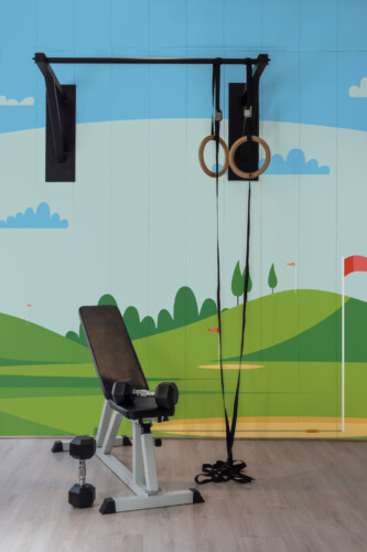 Green Artistic Golf Course Wall Mural with rolling hills, golf flags, and playful green tones, ideal for gyms, kids’ rooms, and sporty game rooms.