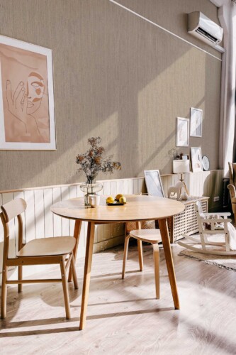 Scandinavian-style dining nook with light wood furniture and minimalist decor, enhanced by the soft woven texture of the Fog Retro Talbott Grasscloth wallpaper in taupe-beige. The design brings a sense of warmth and quiet sophistication. Fancy Walls removable peel and stick or non-pasted wallpaper.
