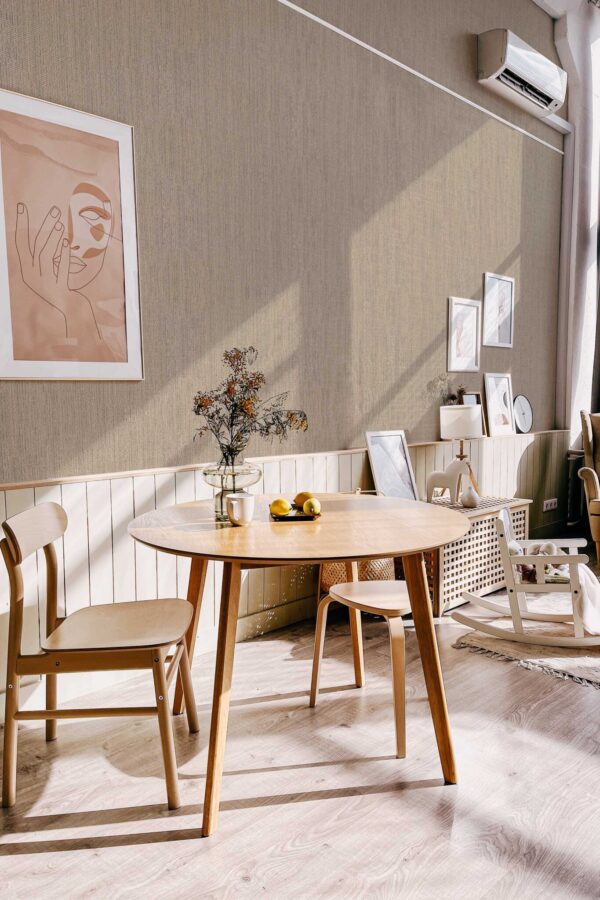 Scandinavian-style dining nook with light wood furniture and minimalist decor, enhanced by the soft woven texture of the Fog Retro Talbott Grasscloth wallpaper in taupe-beige. The design brings a sense of warmth and quiet sophistication. Fancy Walls removable peel and stick or non-pasted wallpaper.