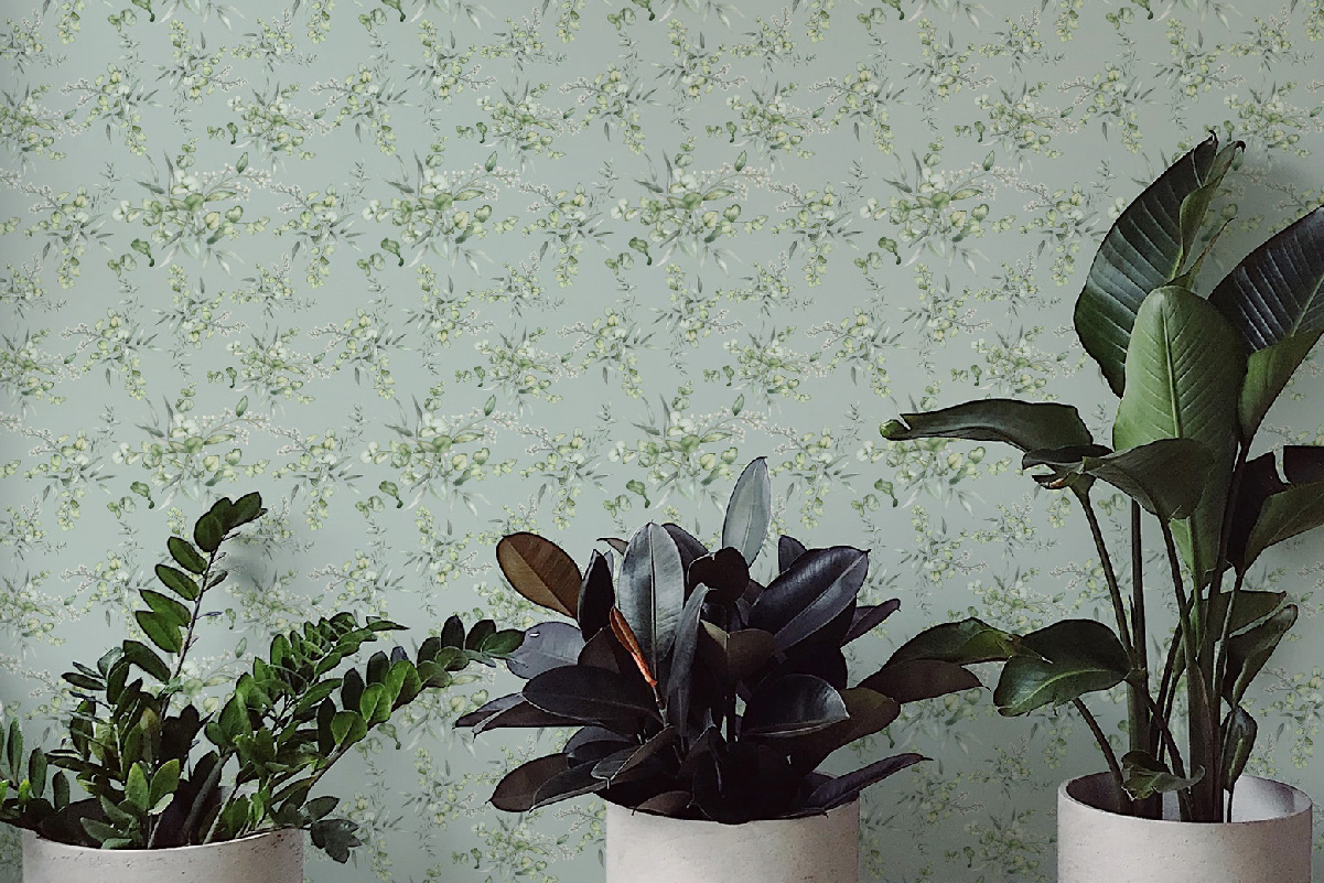 Soft green botanical wallpaper with watercolor-style leaves behind potted plants – perfect for serene interiors and eco-conscious decorating.