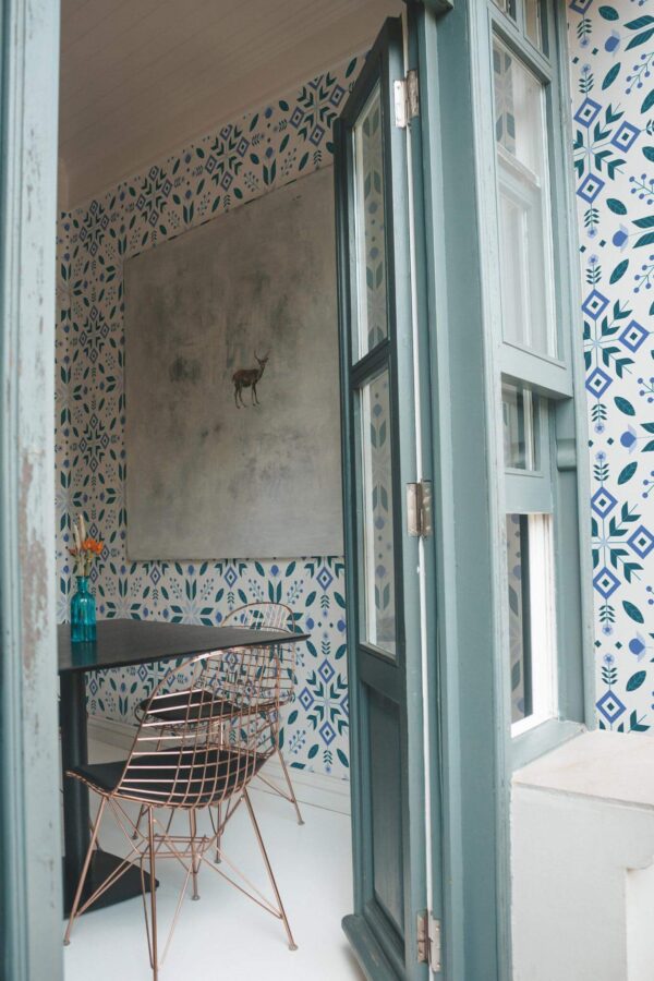 Minimal coastal style cafe decorated with Scandinavian folk art peel and stick wallpaper