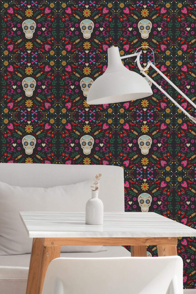 Sugar skull wallpaper with colorful floral and heart motifs on a black background, shown in a modern nook featuring a white table, minimalist lamp, and simple décor.