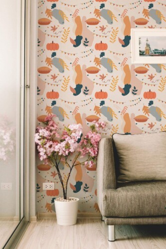 Fun Thanksgiving peel and stick wallpaper with abstract turkeys, pumpkins, and fall leaves in a cozy modern living room with soft décor