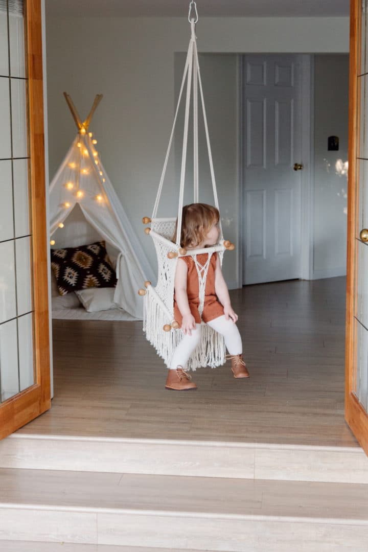 A toddler playing on an indoor swing