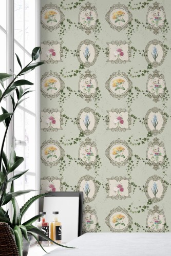 Dollhouse Garden Wallpaper with soft green background, vintage-style floral frames, and scattered ivy motifs, styled in a bright interior corner with large windows and a minimal white tabletop. The whimsical botanical design adds nostalgic charm and a delicate pop of color to the space.