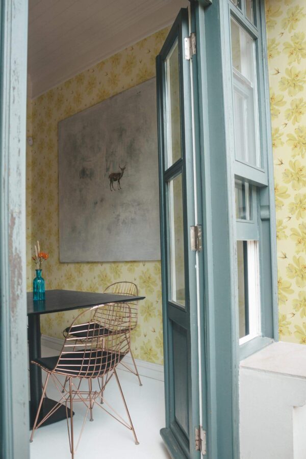Minimal coastal style cafe decorated with Vintage yellow dafodils peel and stick wallpaper