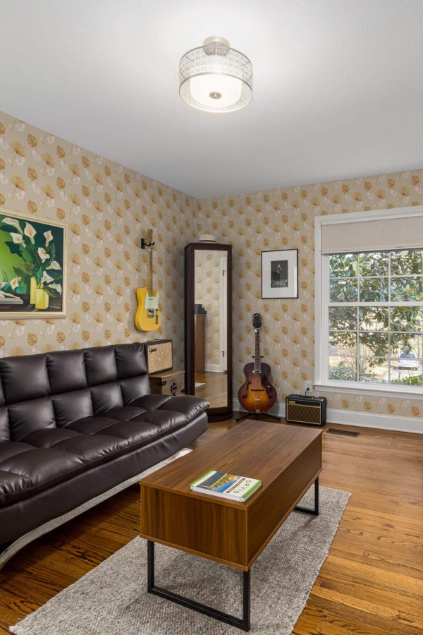 Mid-century style living room decorated with Warm tropical leaf peel and stick wallpaper and music instruments