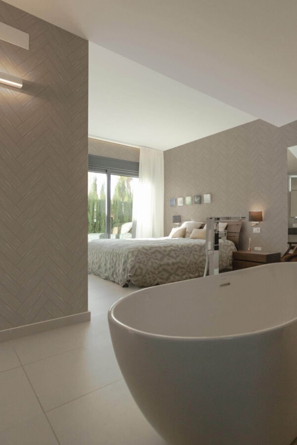 Modern style bedroom with open bathroom decorated with Wood herringbone peel and stick wallpaper