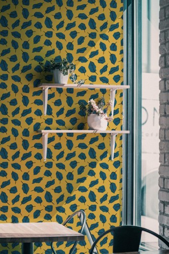 Industrial style cafe decorated with Yellow and blue bold leaf peel and stick wallpaper