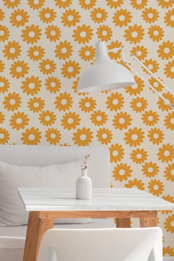 Retro Floral Wallpaper with bold orange daisy motifs on a white background, styled in a minimalist dining nook with a white table, wood legs, and a simple white lamp. The vintage-inspired floral pattern adds warm, cheerful energy to the space.
