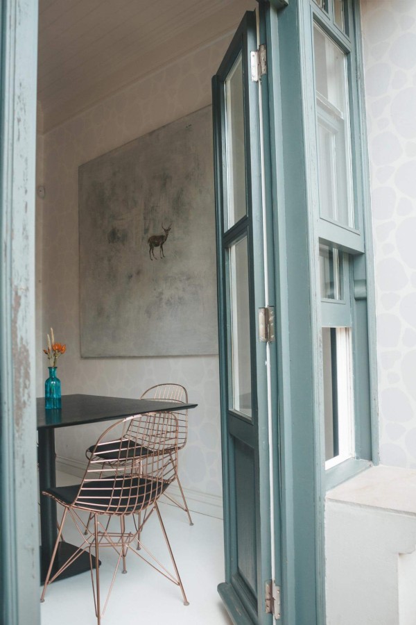 Minimal coastal style cafe decorated with Abstract spots peel and stick wallpaper