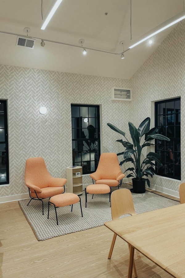 Minimal style living room decorated with Beige Brush stroke herringbone peel and stick wallpaper and mid-century style chairs