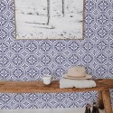 Spanish Tile wallpaper in blue and white octagonal pattern, styled in an entryway with rustic bench, cactus art, and cowhide rug.