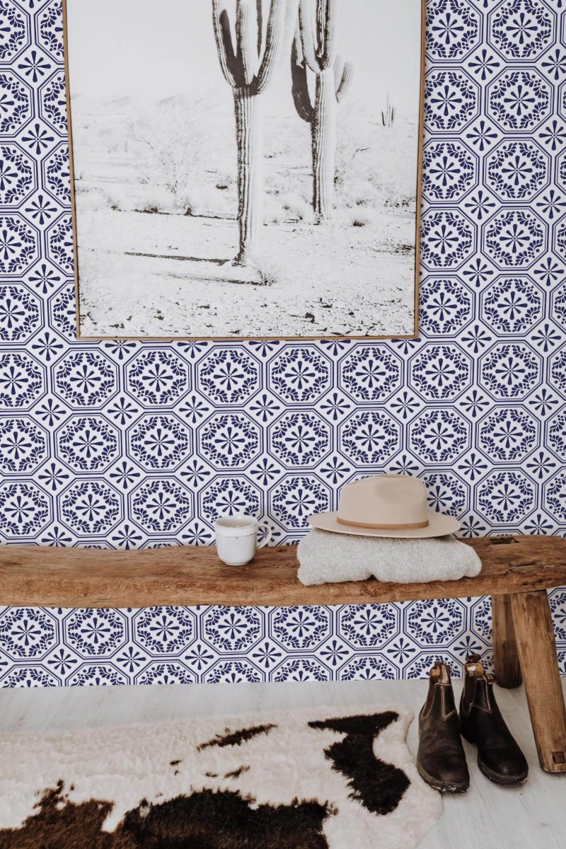 Spanish Tile wallpaper in blue and white octagonal pattern, styled in an entryway with rustic bench, cactus art, and cowhide rug.