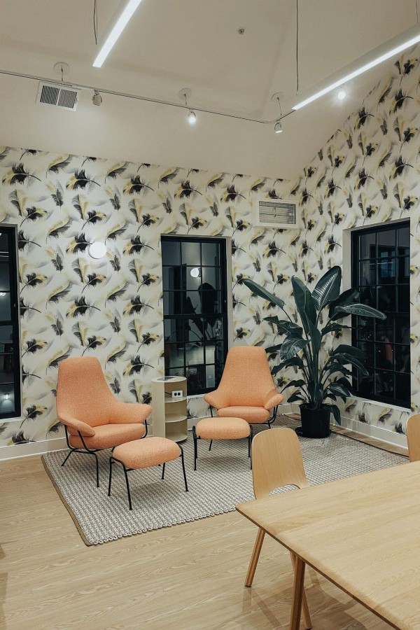 Minimal style living room decorated with Bold feather peel and stick wallpaper and mid-century style chairs