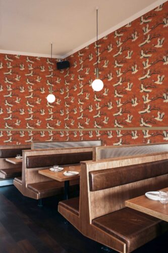 Elegant Flight peel and stick or non-pasted wallpaper for walls. Fancy Walls removable self-adhesive or traditional storks on burnt orange background design PVC-free and eco-friendly wallpaere for bar, cafe, restaurant