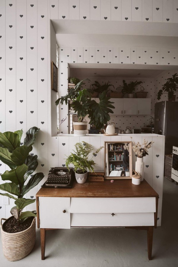 Boho style living room and kitchen decorated with Heart striped peel and stick wallpaper and green plants