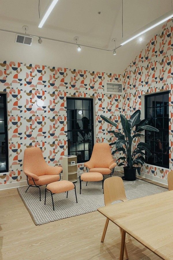Minimal style living room decorated with Midcentury geometric shapes peel and stick wallpaper and mid-century style chairs